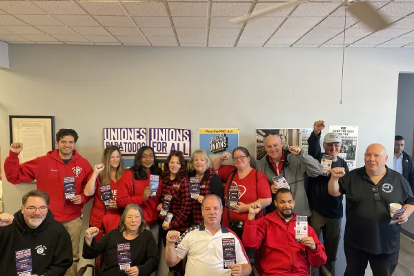 group of union member holding palm cards and raising fists