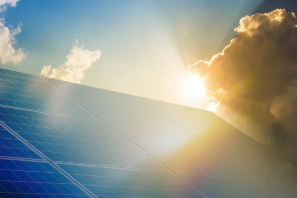 Solar panel with sun shining behind it