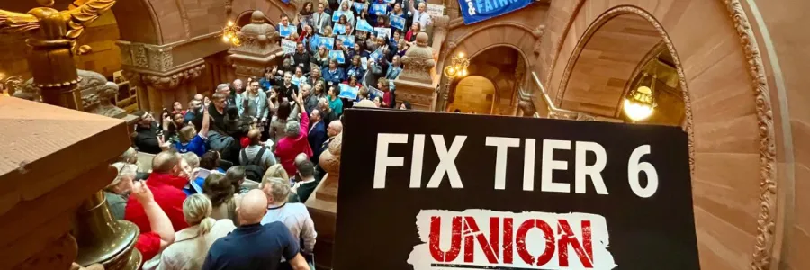 crowd at a tier 6 rally with a fix tier 6 sign in the foreground